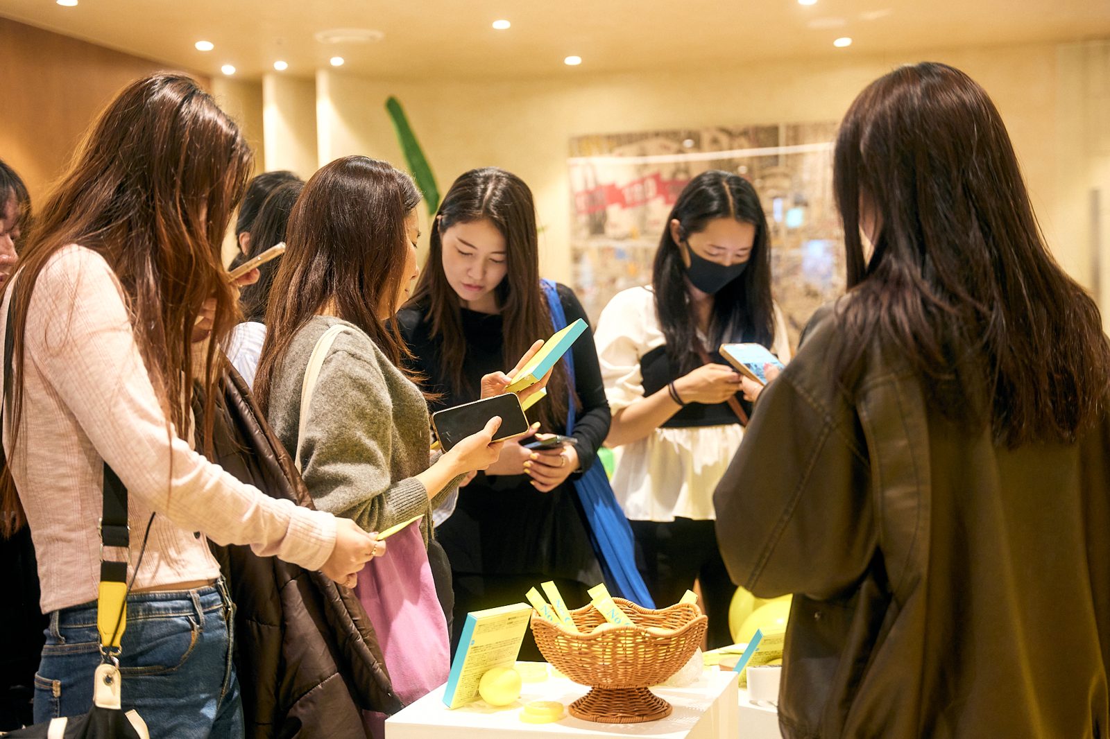 POP UP会場で商品を手に取り、スマートフォンで撮影する来場者
